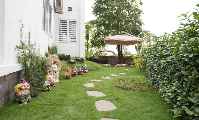 Sân vườn kiểu Âu với thảm cỏ, bồn cây cây cao kết hợp sàn gỗ