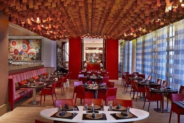 Khung cảnh nhà hàng được thiết kế đơn giản với gam màu đỏ ấn tượng cùng những bộ bàn ghế xinh xắn